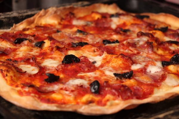 Knusprig dünn: Pizza mit Büffelmozzarella, gebackenen Oliven und Spinata aus Kalabrien